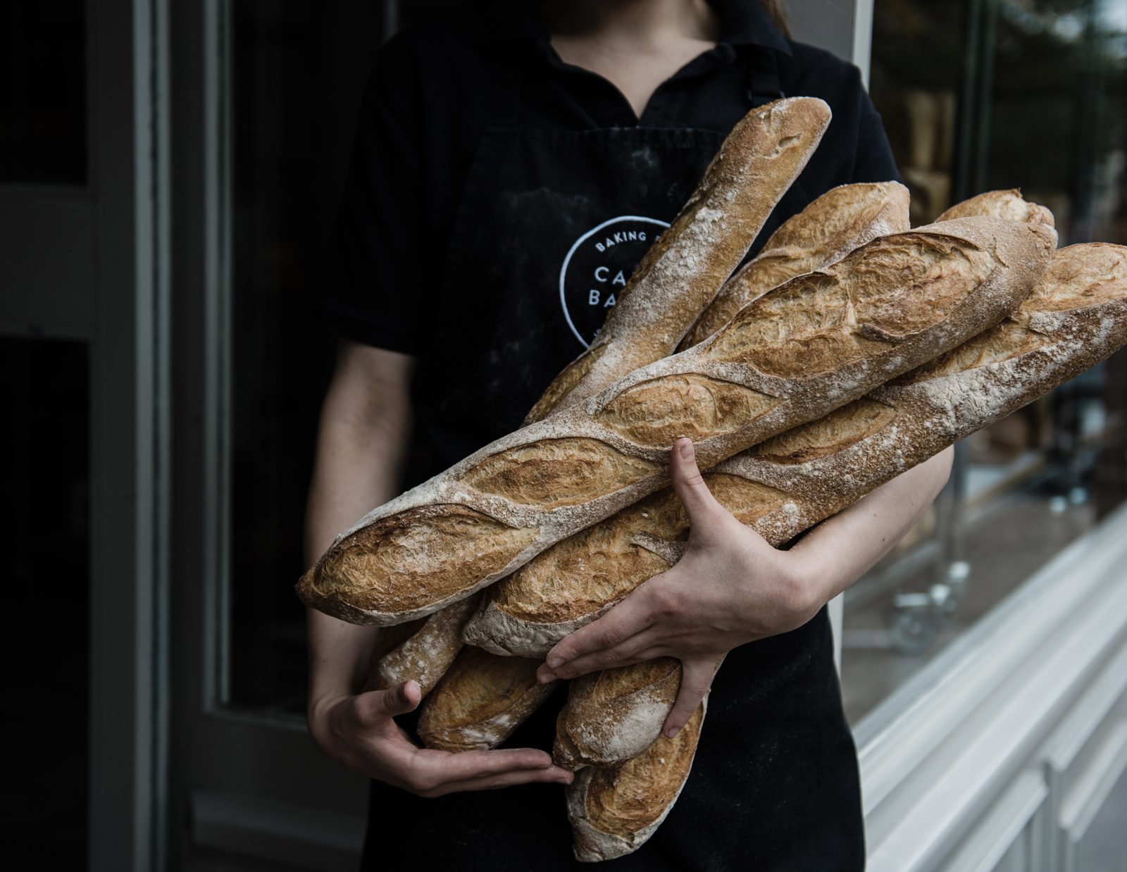 A Cavan team member carrying an armful of baguettes