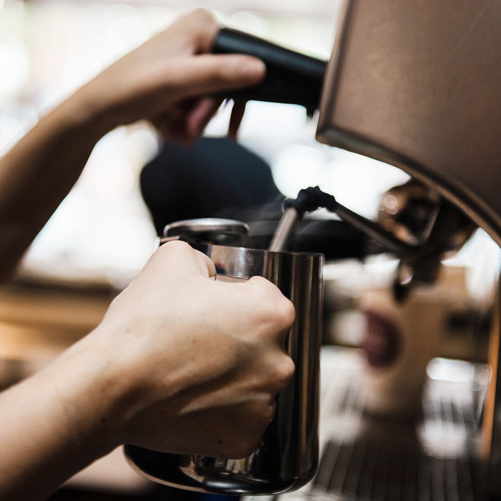 A barista steaming milk at a Cavan coffee machine